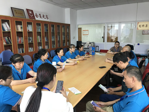 培训现场，大家翻阅宣传单页和“垃圾分类.微信小程序.jpg